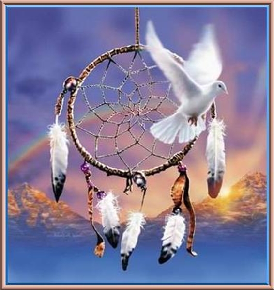 Dreamcatcher, dove, and rainbow over mountains